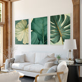 a modern living room with a white sofa, a black coffee table, and three framed prints of tropical leaves on the wall.