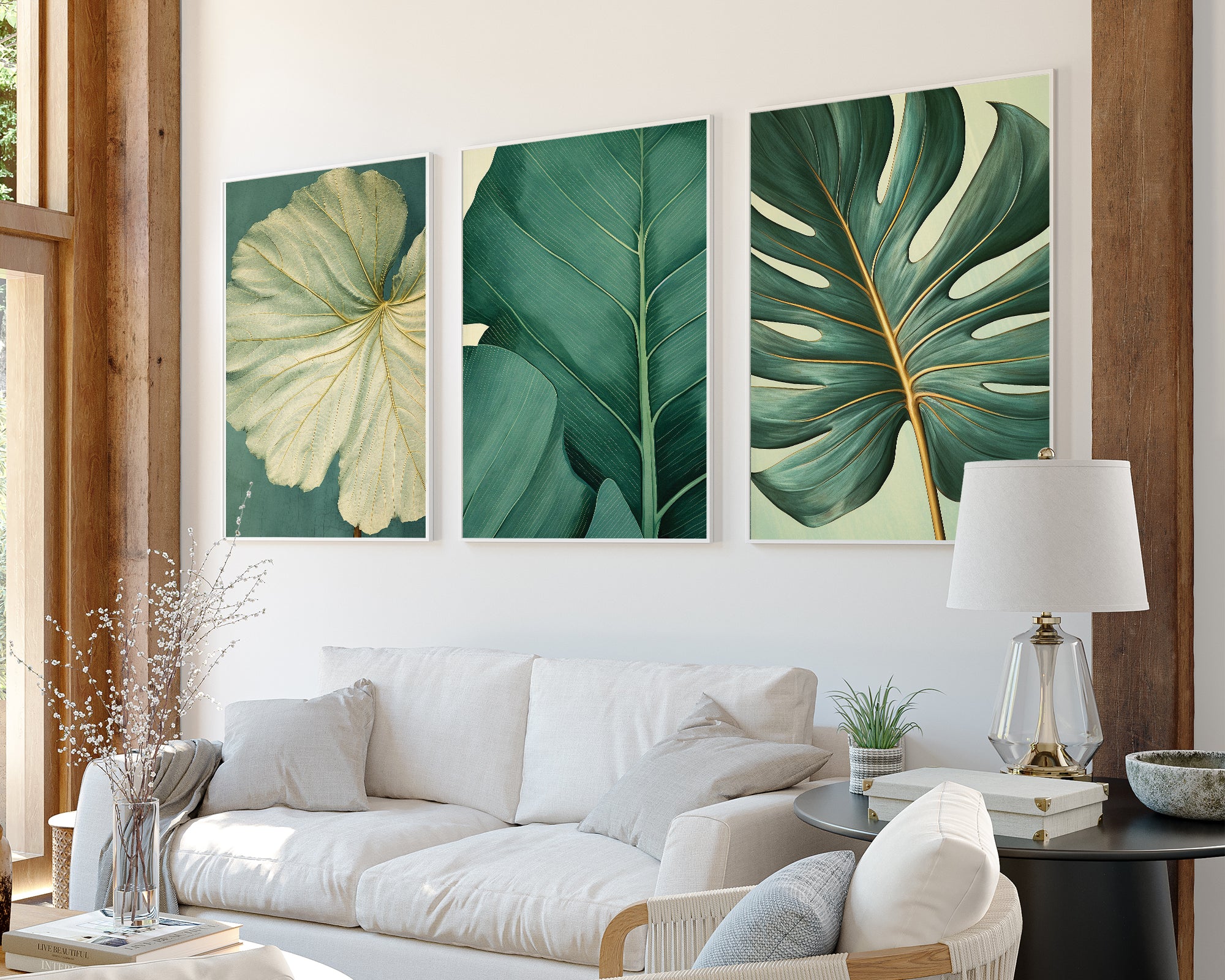 a modern living room with a white sofa, a black coffee table, and three framed prints of tropical leaves on the wall.
