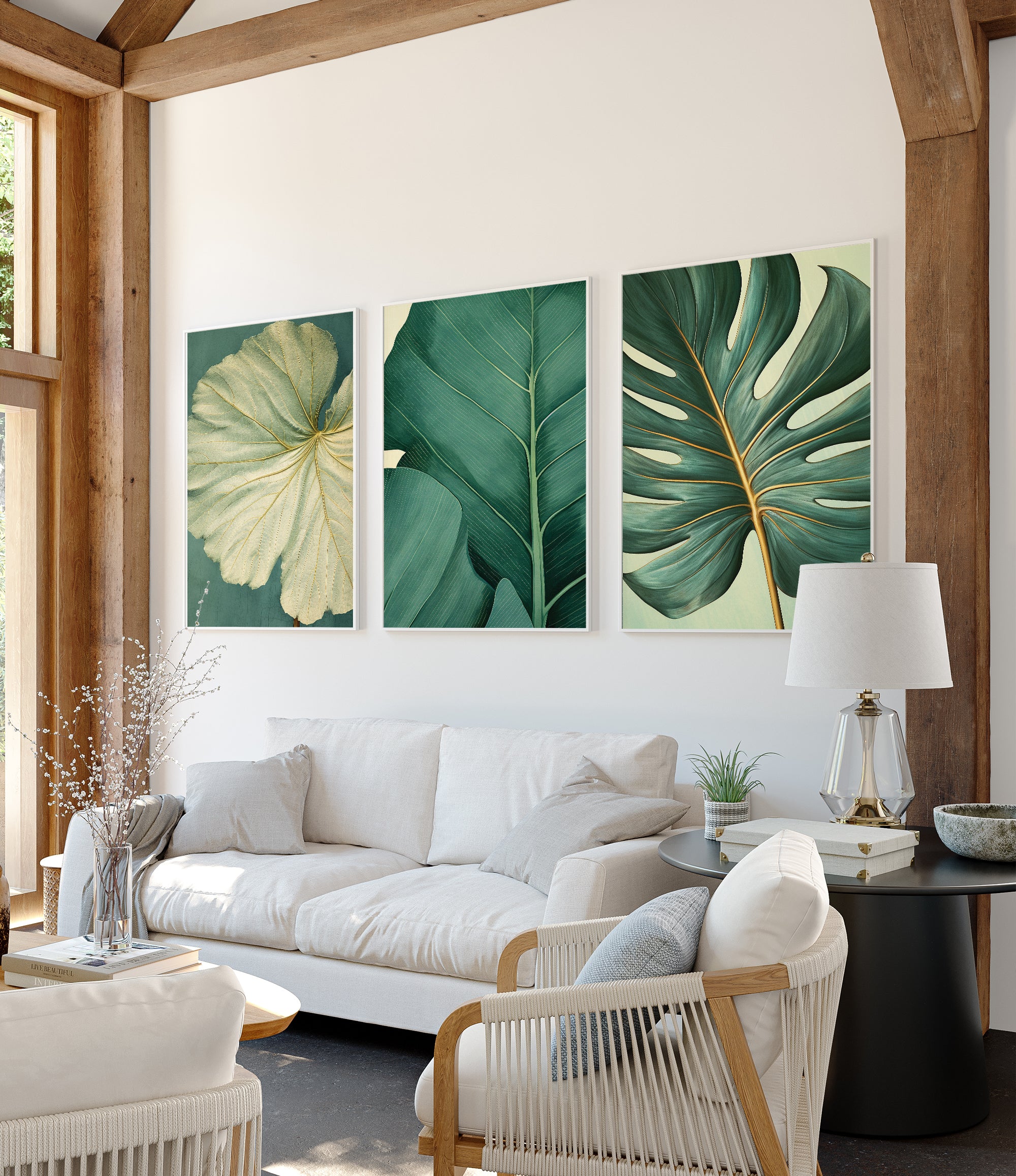 a modern living room with a white sofa, a black coffee table, and three framed prints of tropical leaves on the wall.