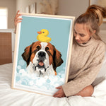 A woman is holding a framed picture of a dog with a yellow rubber duck on its head, which is sitting in a bubble of water.