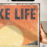 a person holding up a sign that says take life