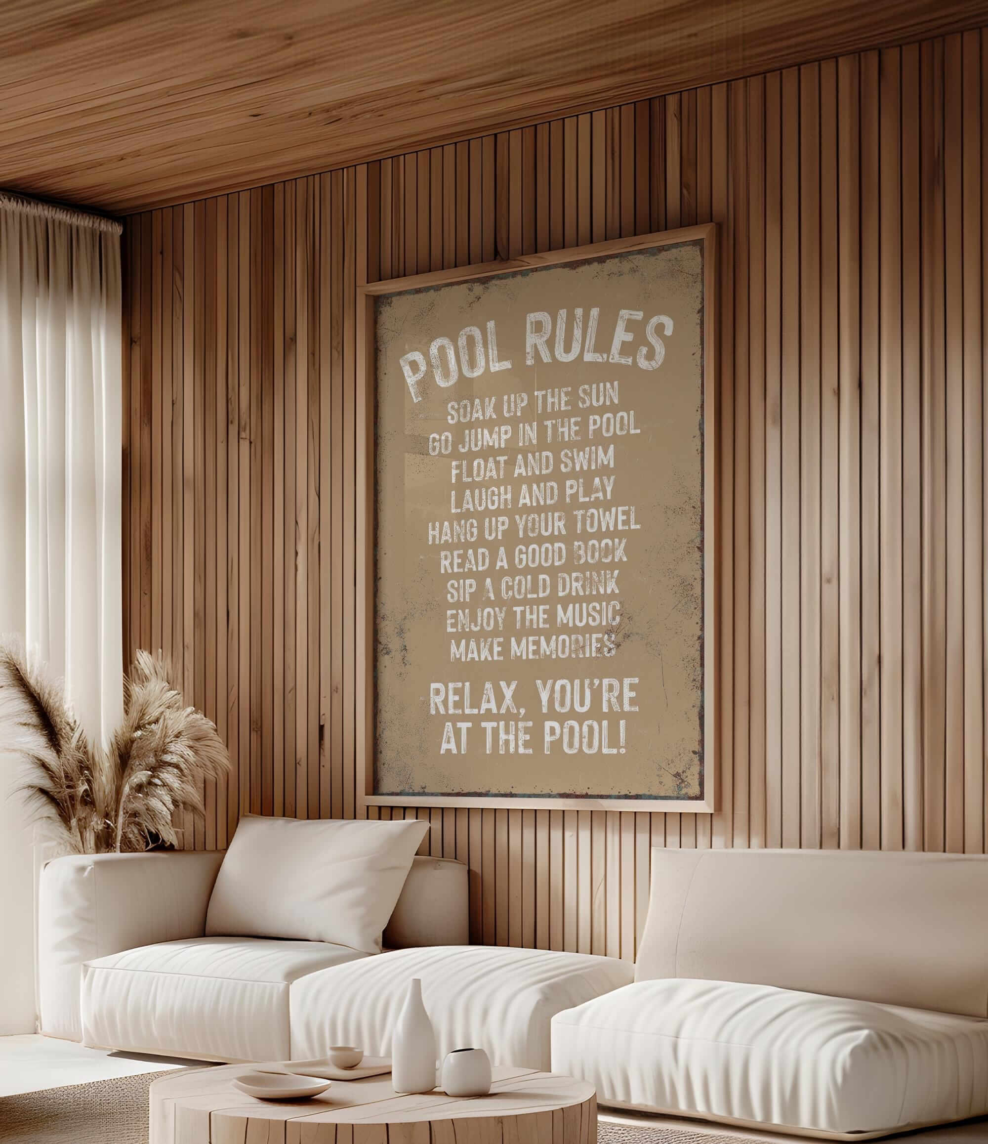 a living room with a white couch and a poster on the wall