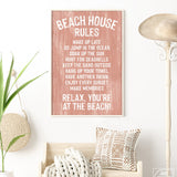 Bright room with coastal wall art, basket, pillows, straw hat, white walls, and a painted wood Coral Beach House Rules Sign.