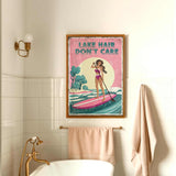 a bathroom with a framed poster of a woman paddleboarding on a lake, along with a towel rack and a bathtub.