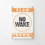 a sign that says slow no wake down