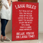 a woman holding a sign that says lanai rules