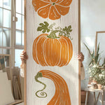 a person holding up a painting of pumpkins