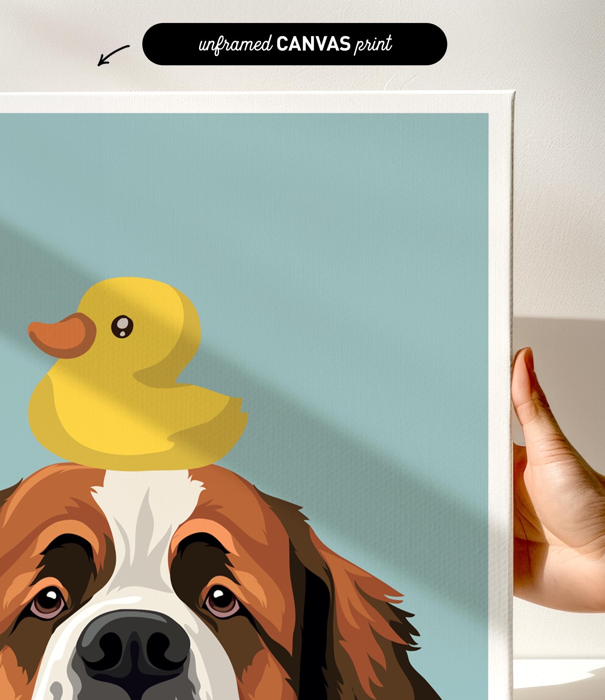 A hand is holding a framed print featuring a cartoon image of a dog with a yellow rubber duck on its head.