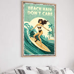 a framed poster with a woman surfing on a wave, with the text "BEACH HAIR DON'T CARE" written above her.
