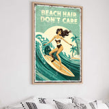 a framed poster with a woman surfing on a wave, with the text "BEACH HAIR DON'T CARE" written above her.