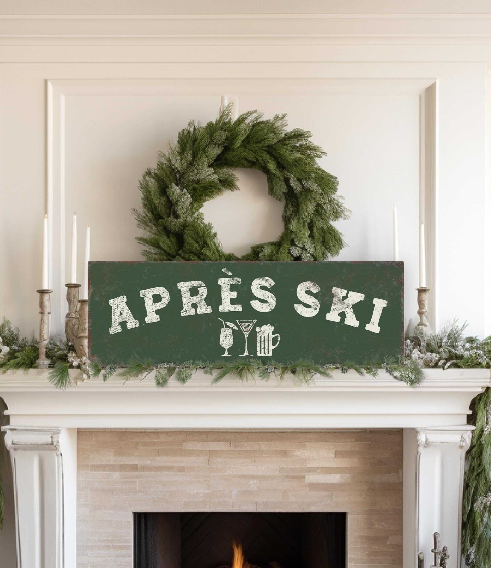 a fireplace mantel decorated with a wreath, candles, and a sign that reads "Apres Ski".