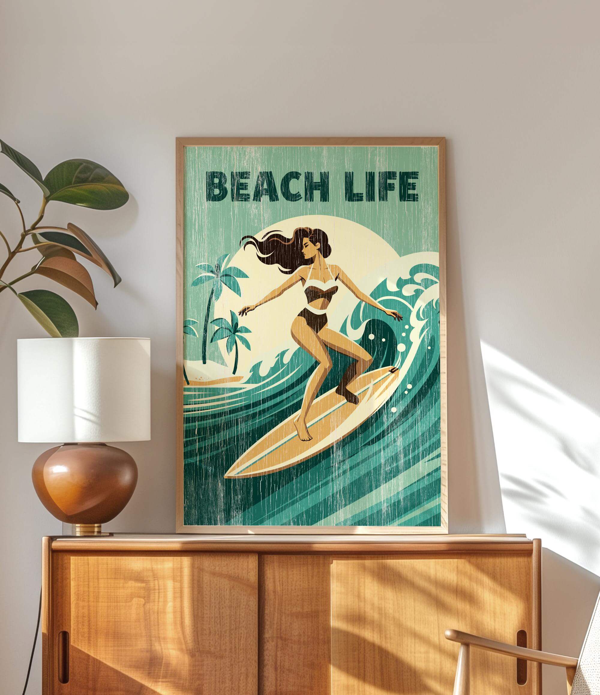 a framed poster of a woman surfing on a wave, with the text "BEACH LIFE" prominently displayed.