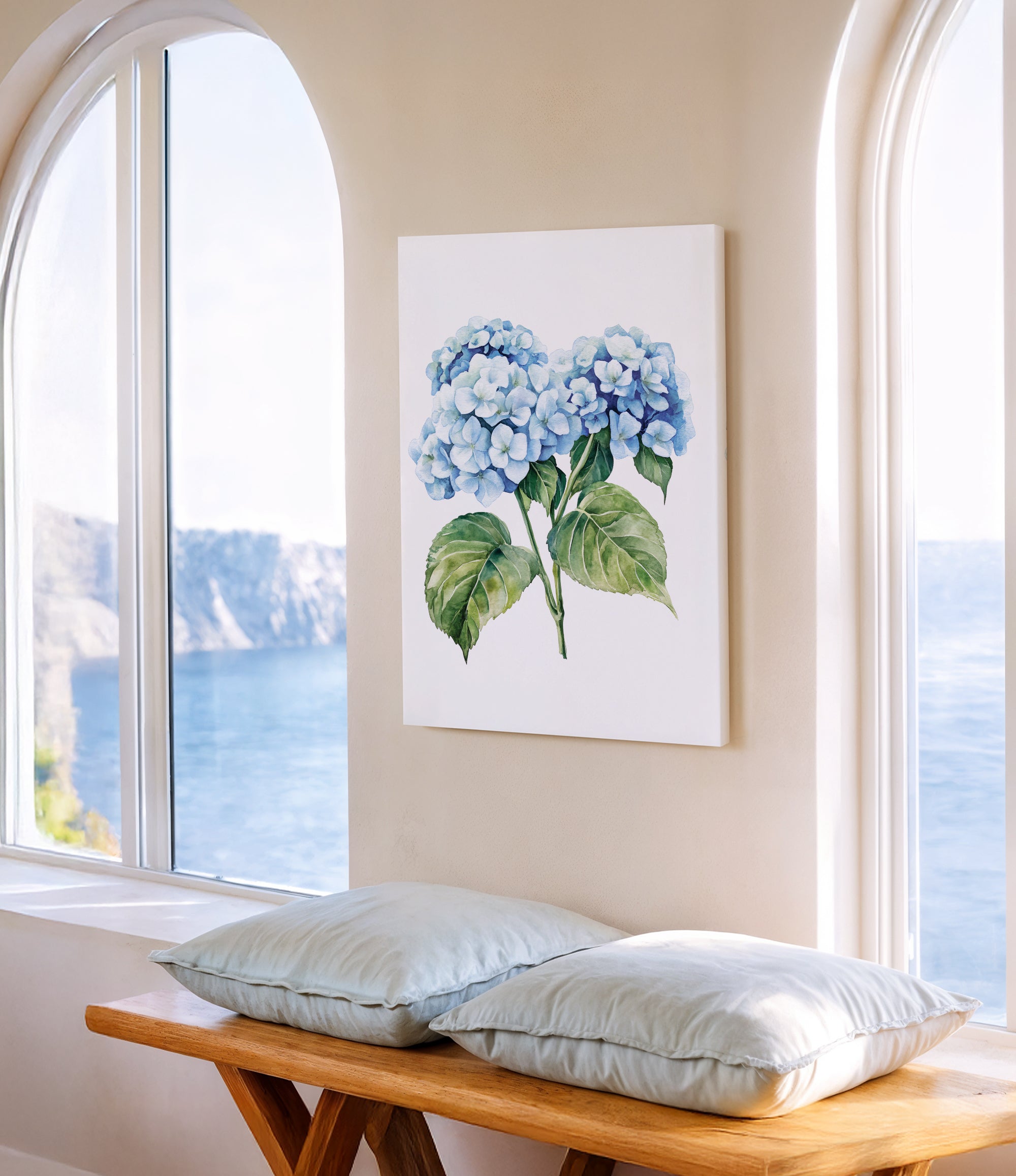 a serene indoor setting with a large window overlooking a picturesque view of the ocean. A painting of blue hydrangeas is displayed on the wall, adding a touch of nature to the space. In front of the window, there is a wooden bench with two pillows, providing a comfortable spot to sit and enjoy the view.