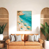 a cozy living room with a large painting of a beach scene hanging on the wall above a brown leather couch. The painting depicts a beach with people enjoying the sun and the sea, surrounded by umbrellas and palm trees. The room is decorated with potted plants and wooden shutters, creating a warm and inviting atmosphere.