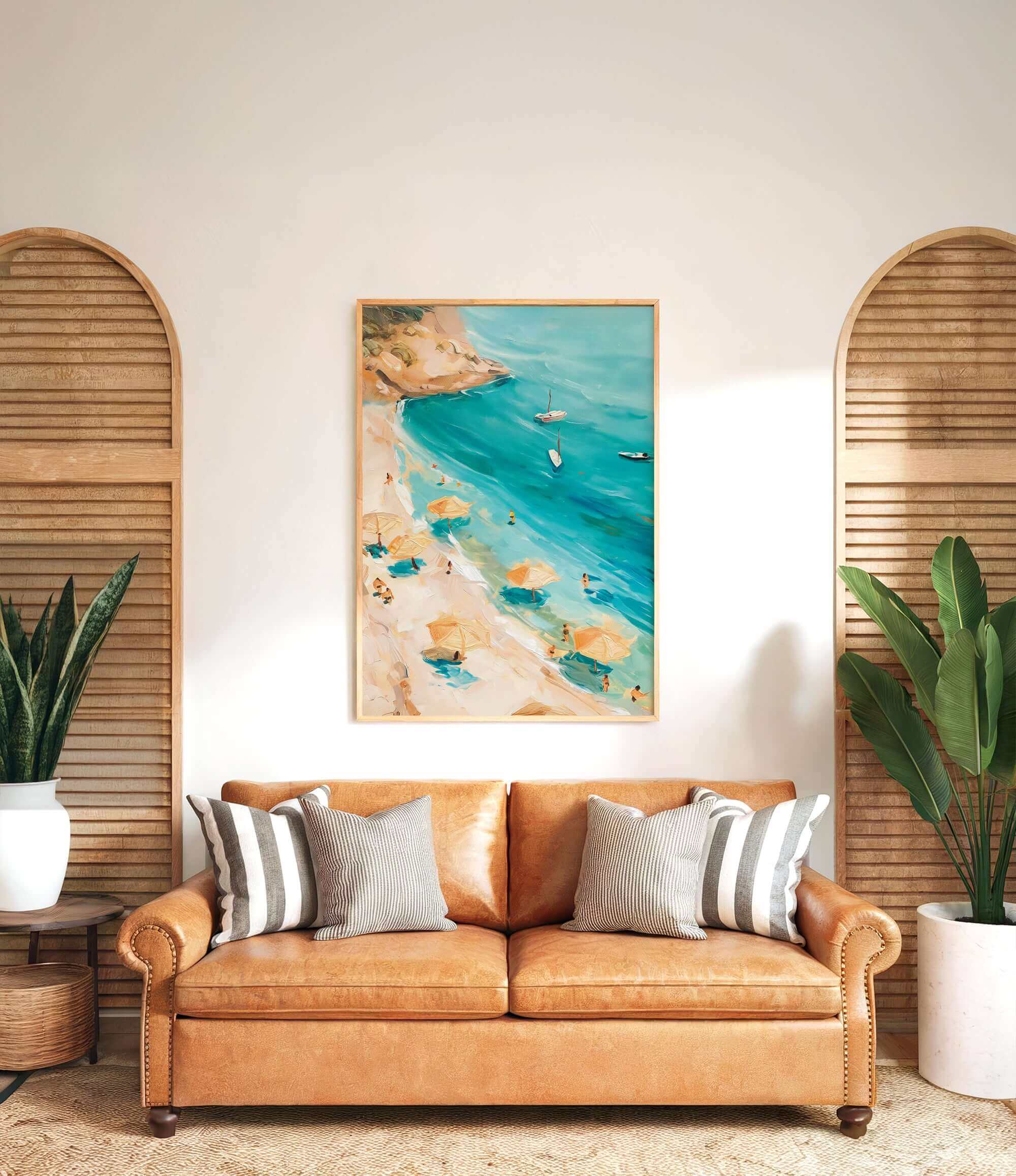 a cozy living room with a large painting of a beach scene hanging on the wall above a brown leather couch. The painting depicts a beach with people enjoying the sun and the sea, surrounded by umbrellas and palm trees. The room is decorated with potted plants and wooden shutters, creating a warm and inviting atmosphere.