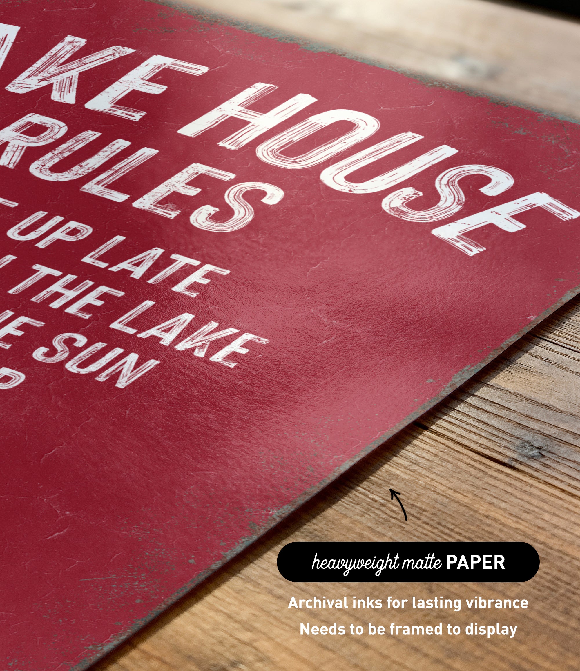 The image is a close-up of a red sign with white text, placed on a wooden surface.