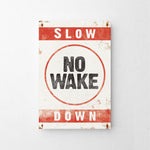 a red and white sign that says slow no wake down