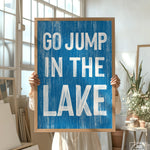 a person holding a sign that says go jump in the lake