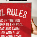 a hand holding a sign that says pool rules