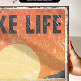 a person holding up a poster that says take life