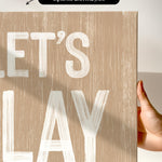 a hand holding a sign that says let&#39;s play