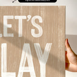 a hand holding a sign that says let&#39;s play