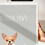 a hand holding a white canvas print with a dog illustration on it.