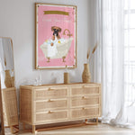 a pink poster of a dog in a bathtub, hanging on a wall above a wooden dresser with drawers.