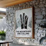 a stone wall with a sign that says the mountains are calling