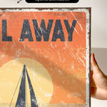 a hand holding a poster with a sailboat on it