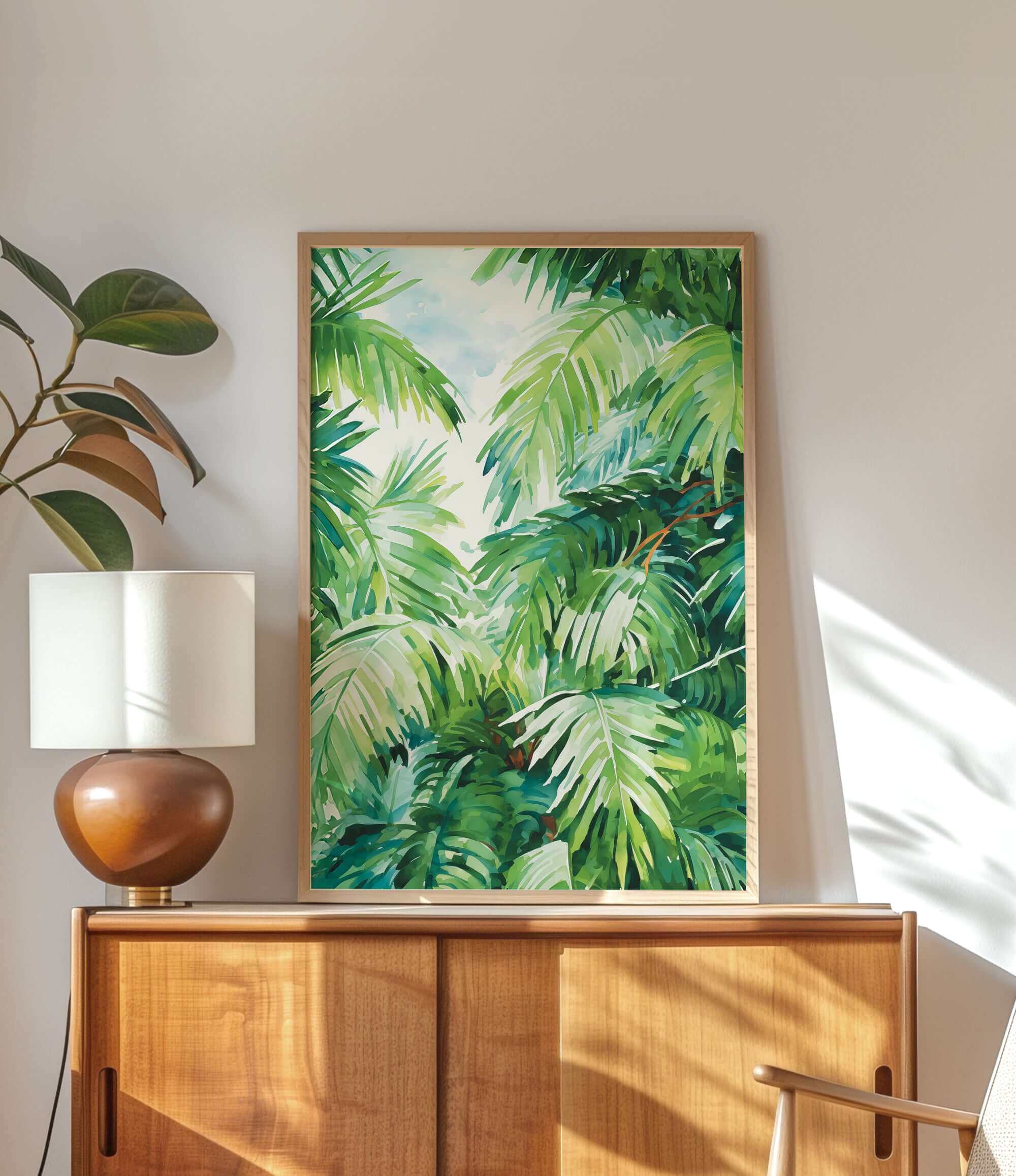a wooden cabinet with a lamp on top, and a framed painting of lush green palm leaves hanging on the wall above the cabinet.