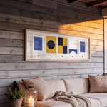 a cozy living space with a wooden wall, a beige sofa, and a framed artwork hanging above it. The artwork displays the word "SILAS" in a creative and artistic manner.