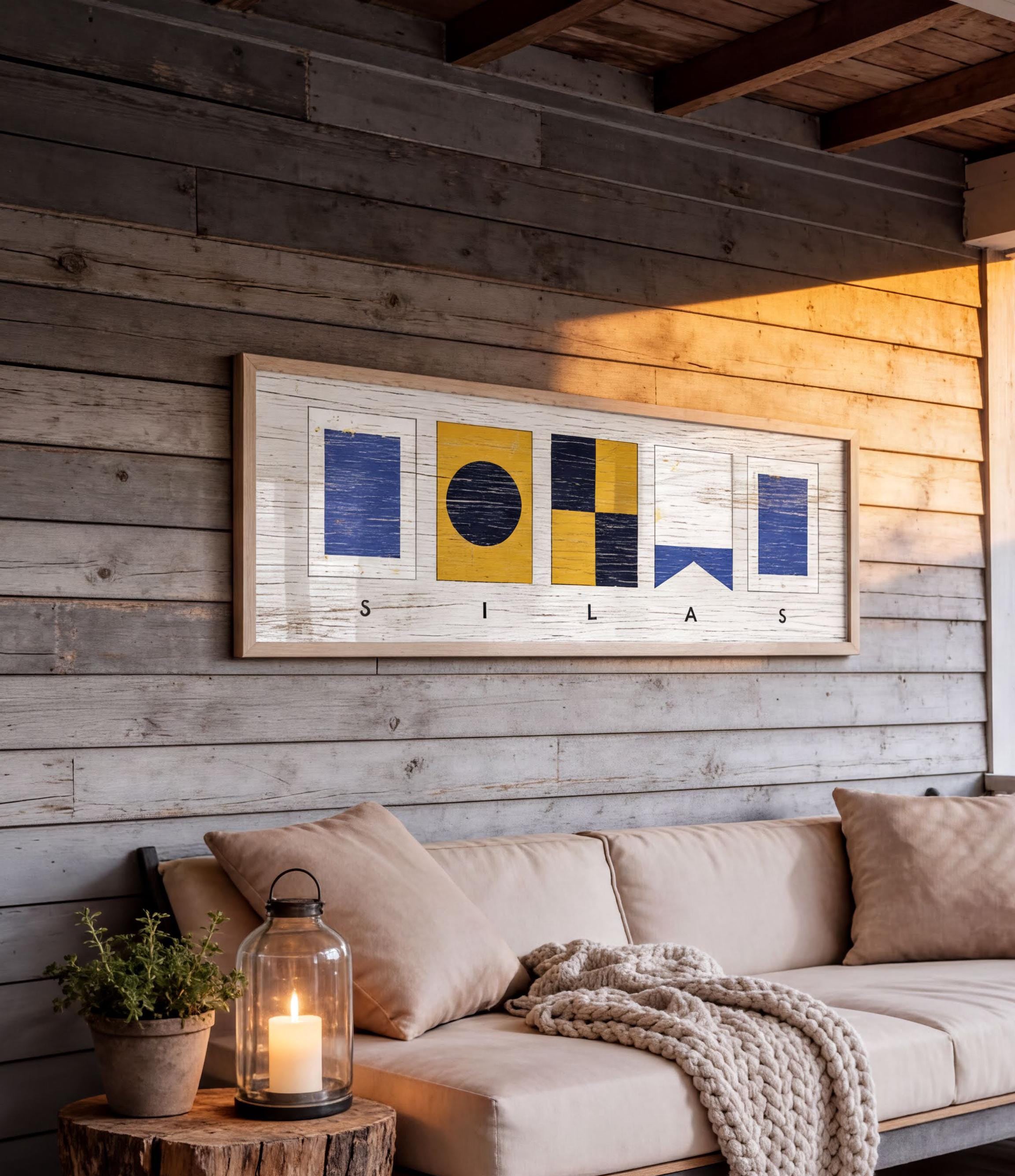a cozy living space with a wooden wall, a beige sofa, and a framed artwork hanging above it. The artwork displays the word "SILAS" in a creative and artistic manner.