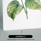 The image is an aluminum print featuring a watercolor painting of a flower with green leaves.