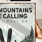 a hand holding a sign that says mountains are calling