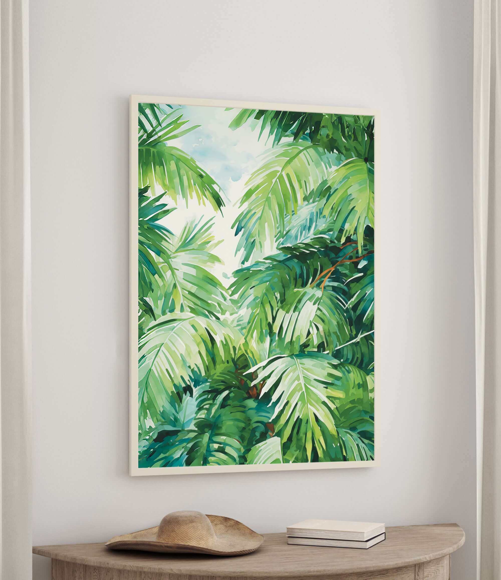 a large framed painting of lush green palm leaves hanging on a wall above a wooden table.