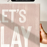 a person holding a sign that says let&#39;s play