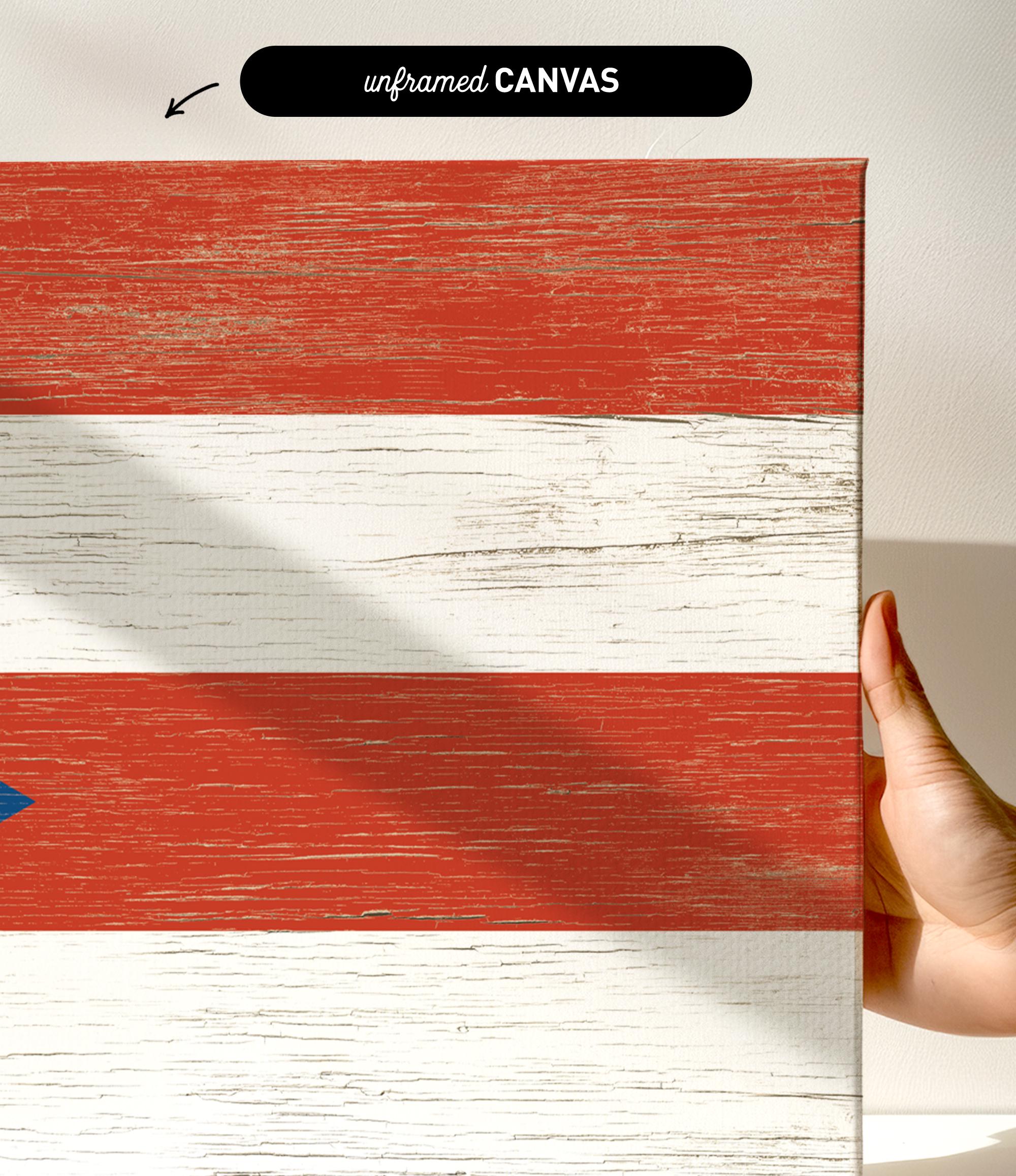 a hand holding a piece of wood with a flag painted on it