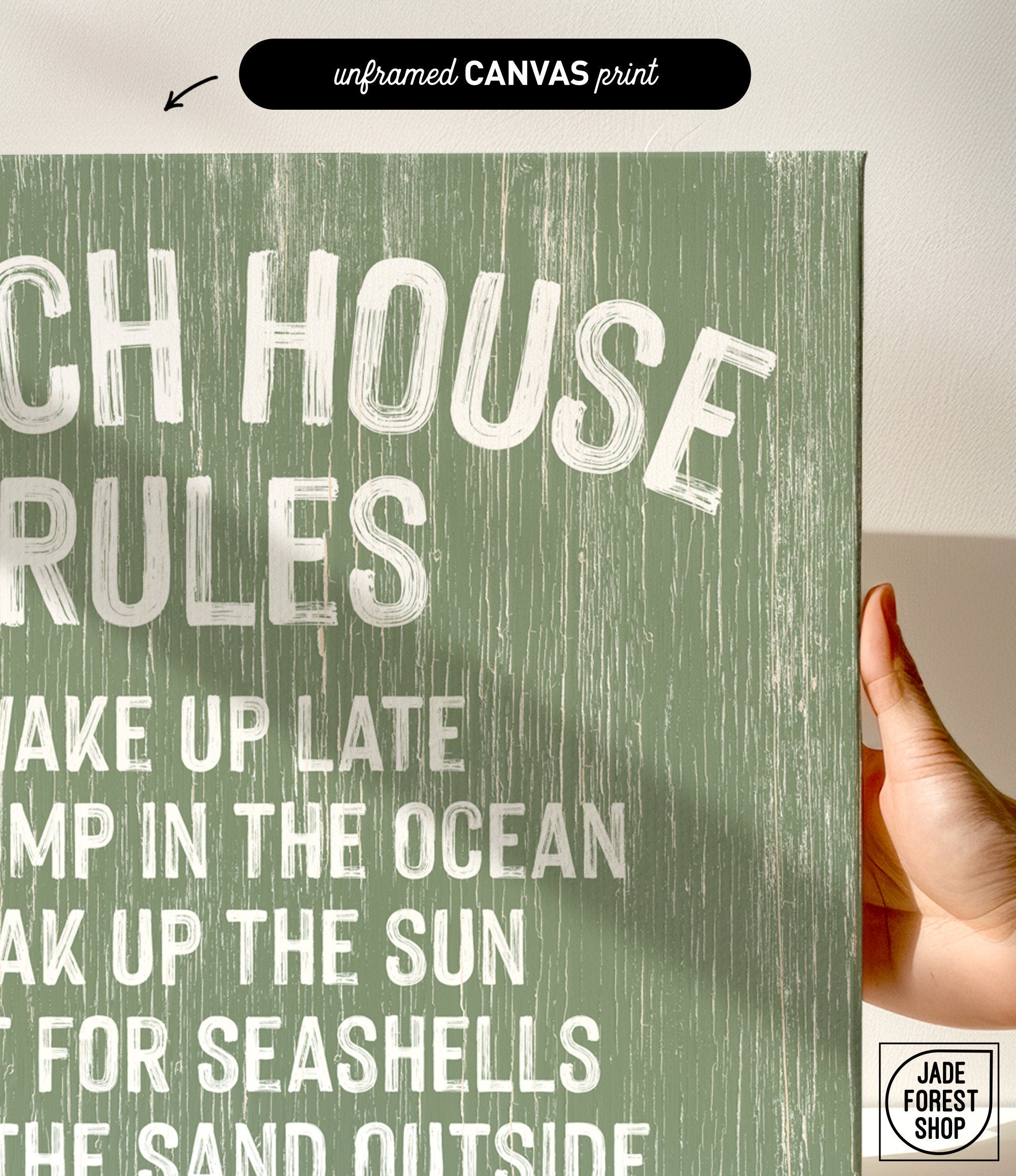 A hand holds a Beach House Rules Sign, crafted from painted wood in seagrass color with white text, perfect as beach house wall decor and bathed in sunlight.