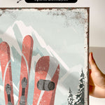 a person holding up a picture of a pair of skis