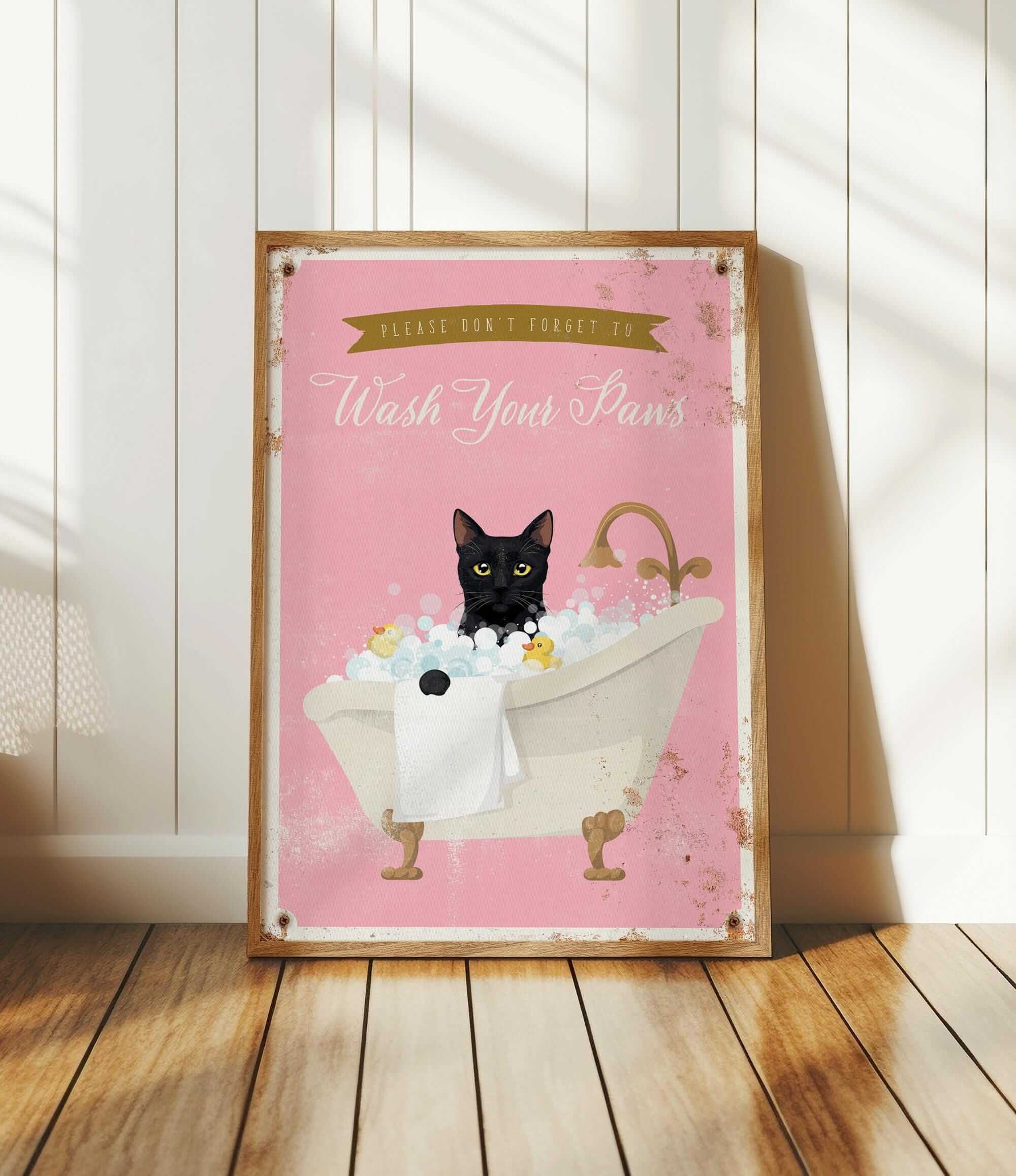 A framed poster with a black cat sitting in a bathtub filled with bubbles, accompanied by the text "Please don't forget to wash your paws".