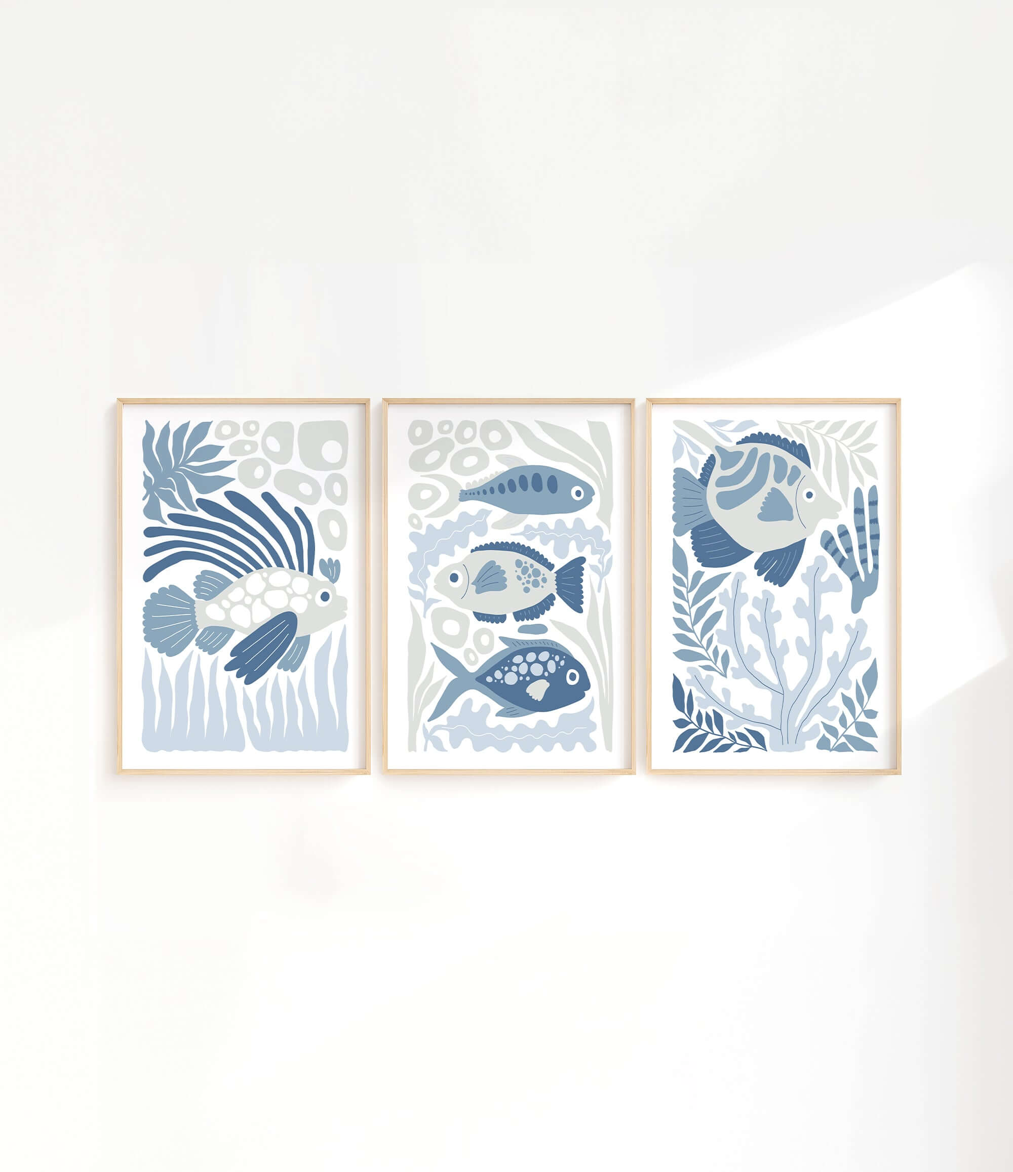 three paintings of fish on a white wall