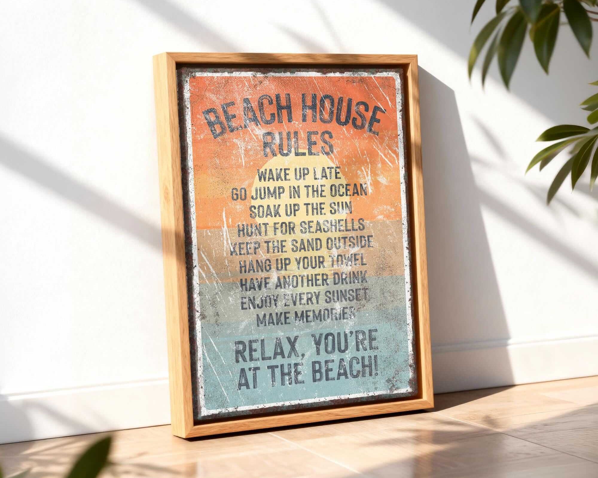 A framed sign with the text "BEACH HOUSE RULES" is displayed on a wooden floor, with a plant in the background.
