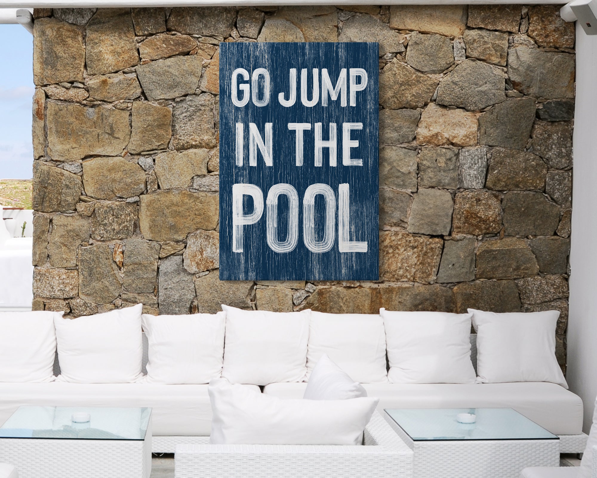 a white couch sitting in front of a stone wall