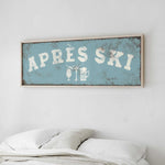 a bedroom with a bed and a framed sign that reads "APRES SKI" above it.