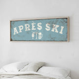 a bedroom with a bed and a framed sign that reads "APRES SKI" above it.