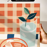 The image is a hand holding a canvas print featuring a glass of water with ice cubes, a plant, and a bowl of food.