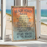 A framed sign with beach rules posted in a beach house, with a view of the ocean through a window.