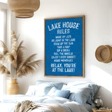 a bedroom with a large blue sign that reads "LAKESHORE RULES" hanging on the wall. The sign lists various lake-related activities and rules, such as "WAKE UP LATE GO JUMP ON THE LAKE COAT UP THE SUN TAKE A NAP FEEL THE BREEZE ENJOY EVERY SUNSET MAKE MEMORIES RELAX YOU'RE AT THE LAKE!" The room has a bed, a potted plant, and a woven basket, creating a cozy and relaxing atmosphere.