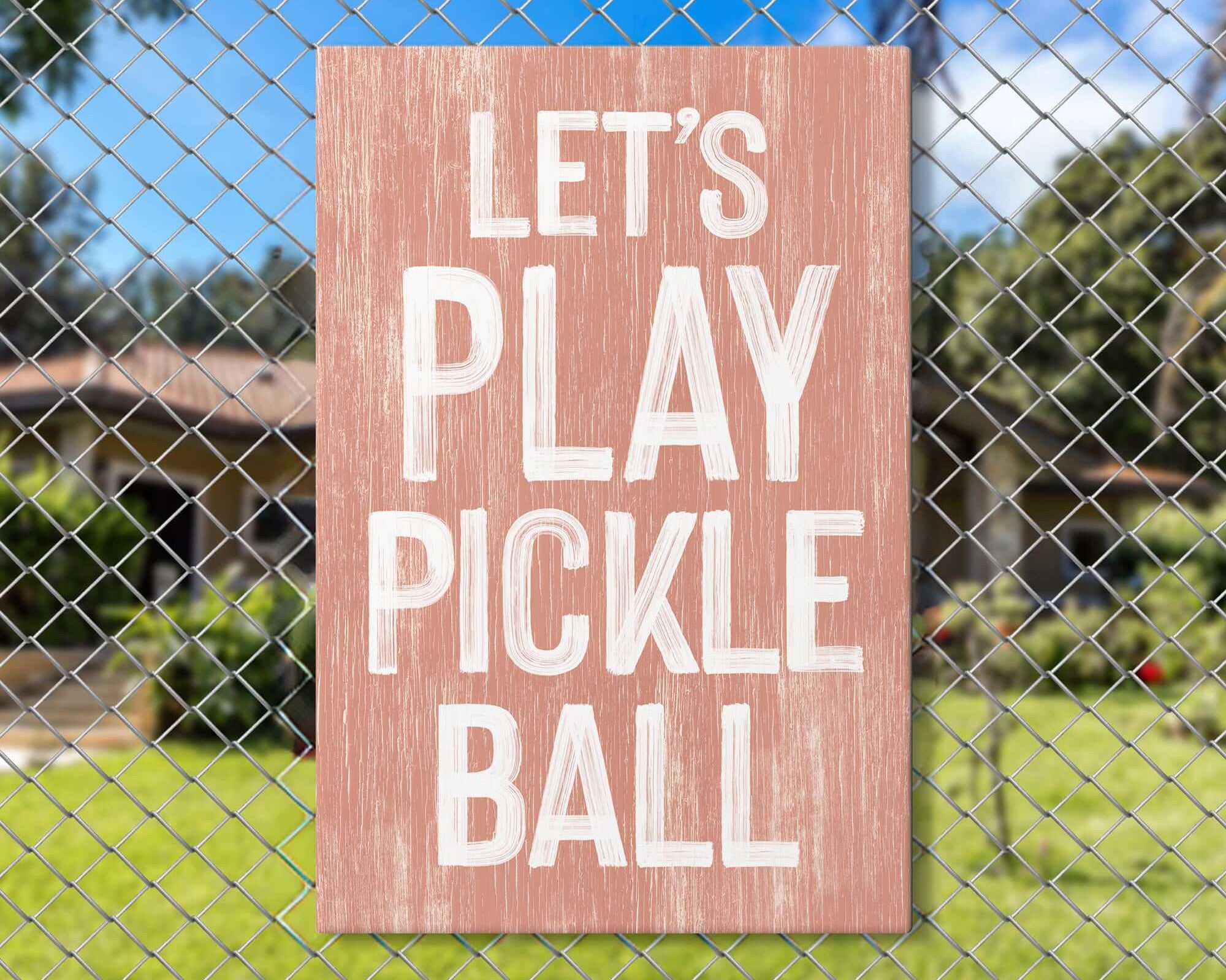 a sign on a fence that says let's play pickle ball
